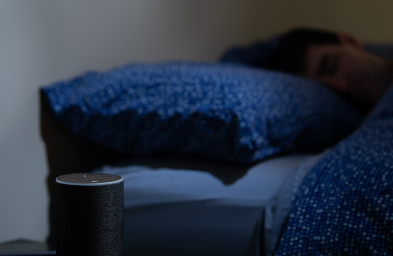 Una persona durmiendo y dispone de un asistente virtual para monitorizar su respiración. 