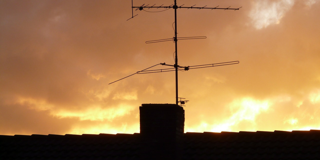 Una antena de televisión encima de una vivienda.