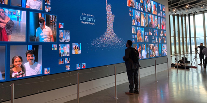 Una persona delante del vídeo wall LED del museo de la Estatua de la Libertad.