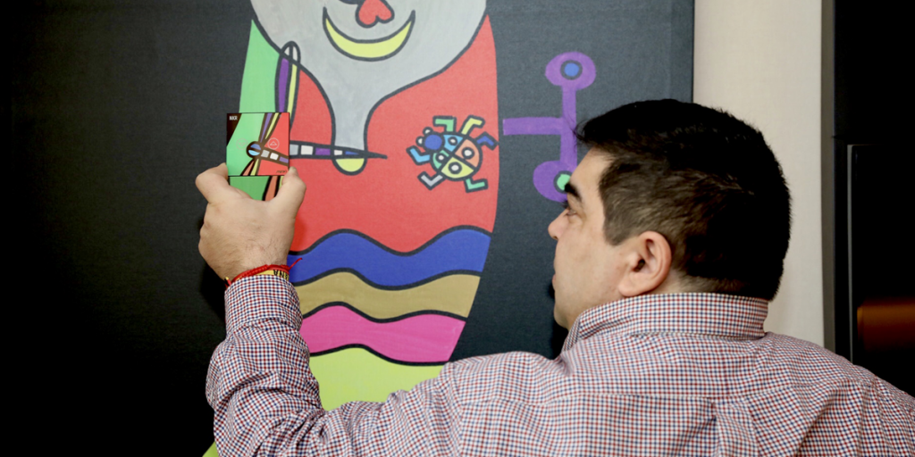 El artista mallorquín José Luis Mesas delante de su obra sujetando uno de los dispositivos de ROBOTBAS.