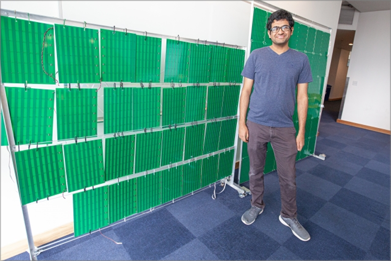 Venkat Arun uno de los investigadores de MIT delante de la superficie inteligente que contiene más de 3.000 antenas. 