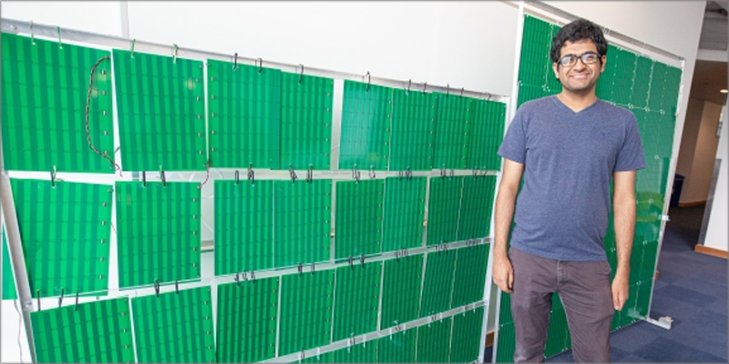 Venkat Arun uno de los investigadores de MIT delante de la superficie inteligente que contiene más de 3.000 antenas.