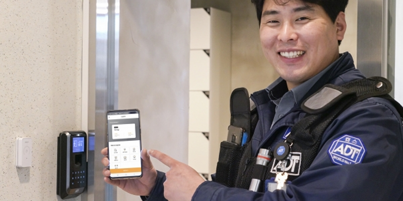 Uno de los empleados de SK Telecom con el móvil al lado de una cerradura inteligente.