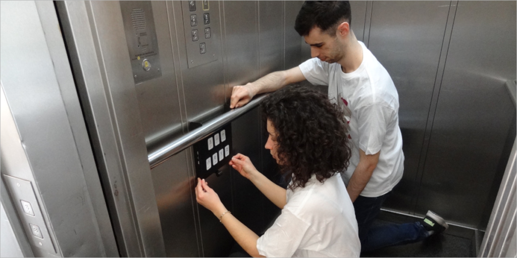 Investigadores de la Universidad de Lleida instalando la botonera sin contacto.
