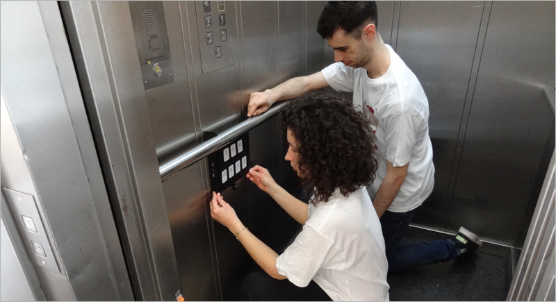 Investigadores de la Universidad de Lleida instalando la botonera sin contacto.